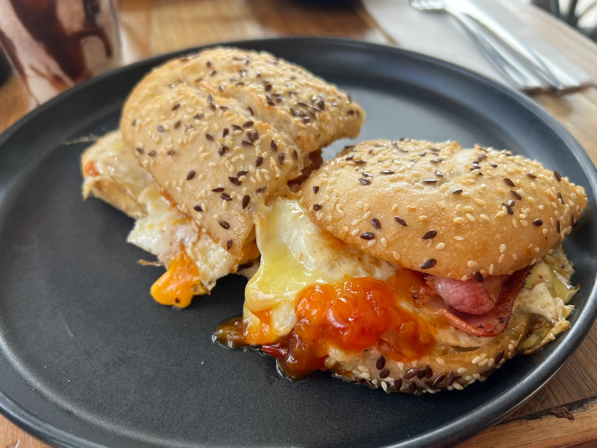 Toasted seeded roll sandwich with egg, cheese, bacon and relish