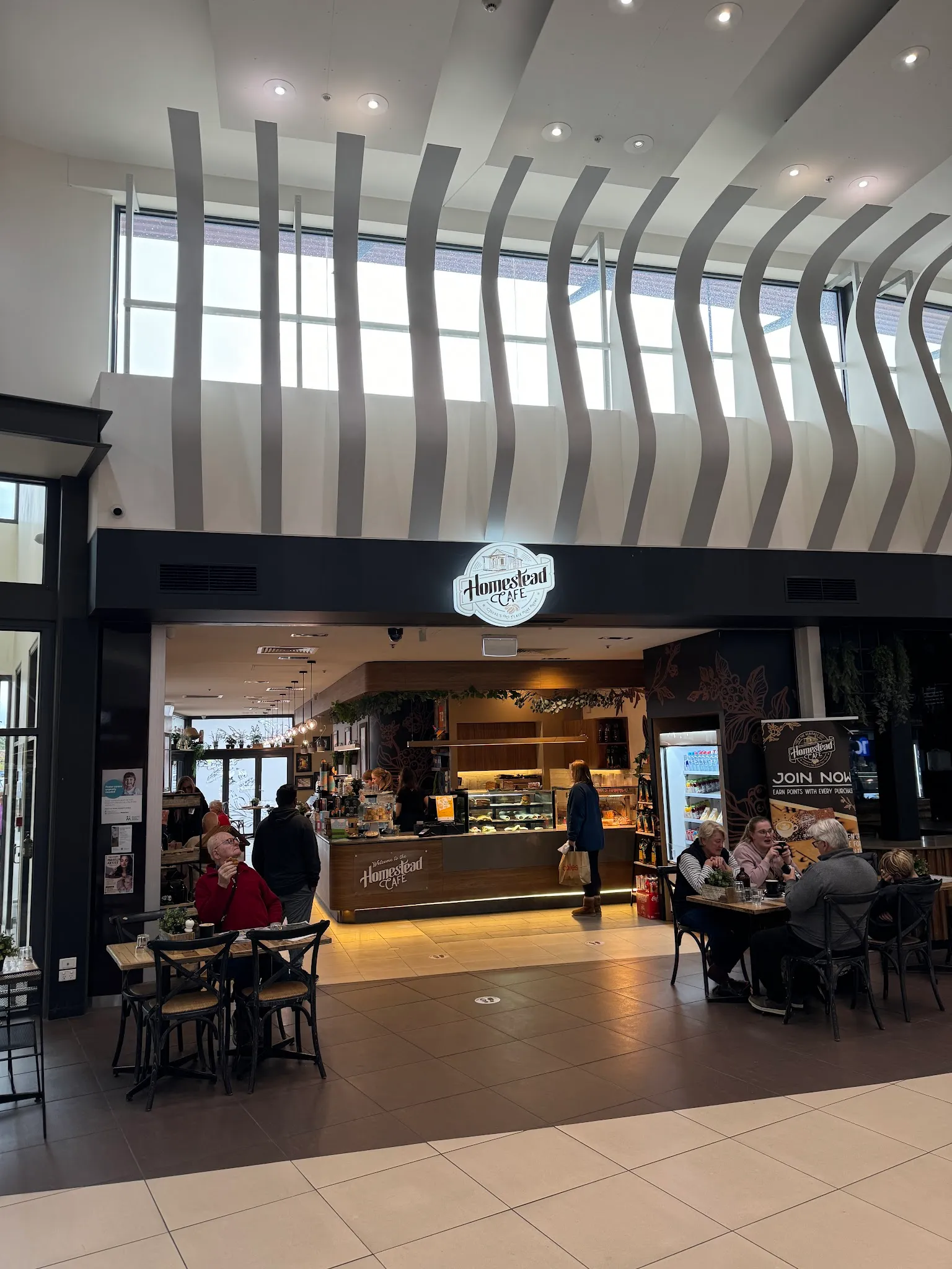 Homestead Cafe entrance with high ceiling and seated customers