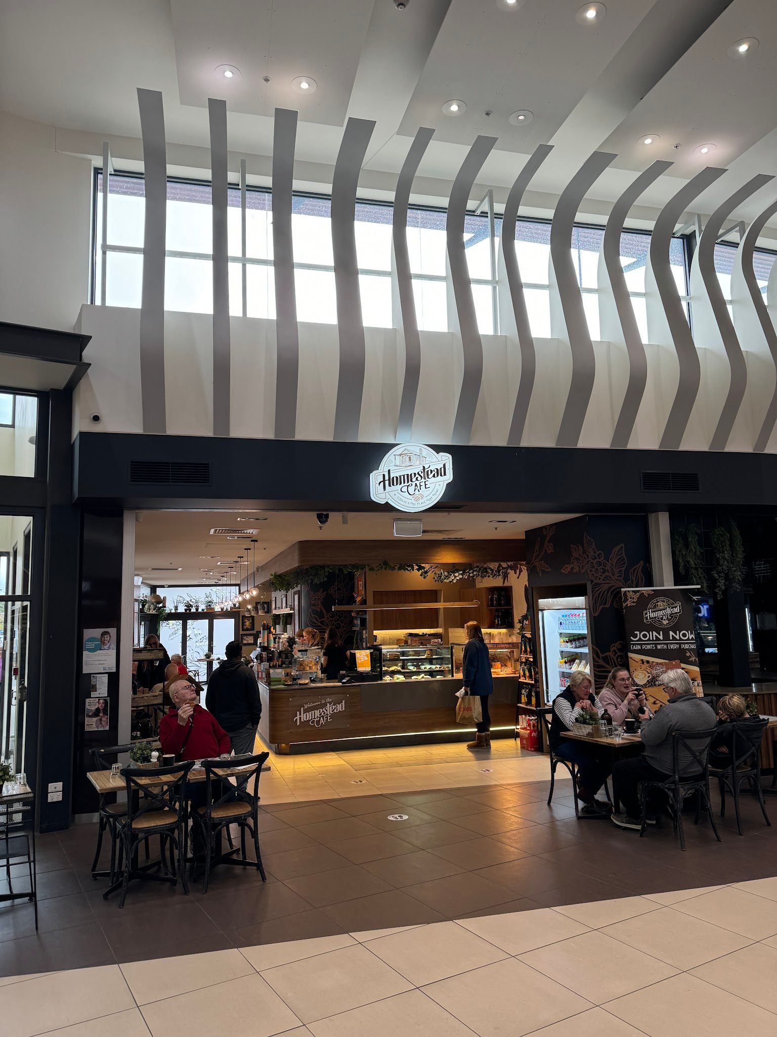 Homestead Cafe entrance with high ceiling and seated customers
