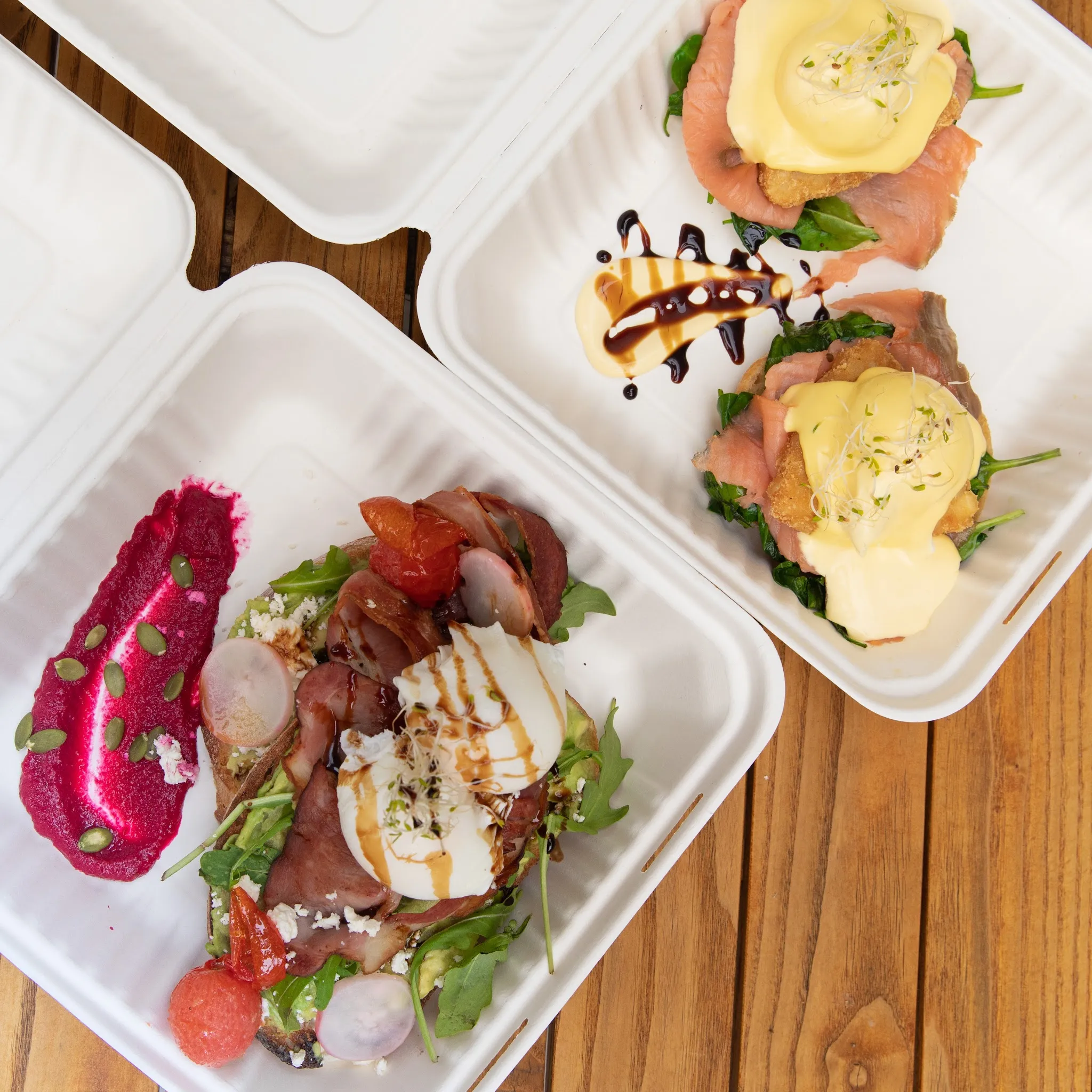 Two takeaway brunch containers with avocado toast and salmon